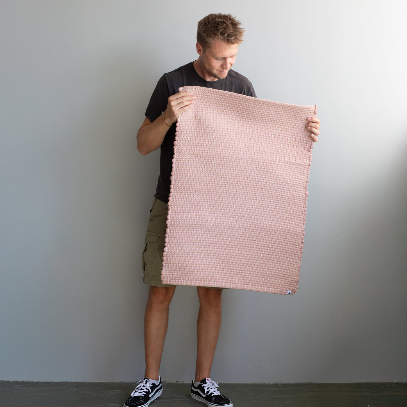 60x90cm petit tapis tenu par une personne en vieux rose rayé avec du jute tissé à la main au Portugal