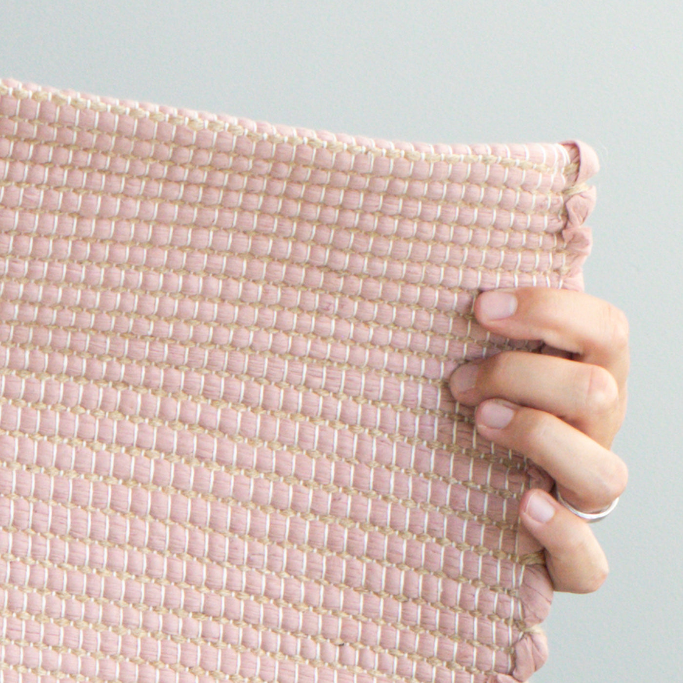 Close-up d'un petit tapis 60x90cm en vieux rose avec jute rayé en restes de laine de l'industrie textile tissé à la main au Portugal