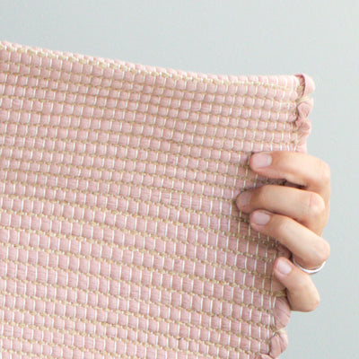 Close-up d'un petit tapis 60x90cm en vieux rose avec jute rayé en restes de laine de l'industrie textile tissé à la main au Portugal