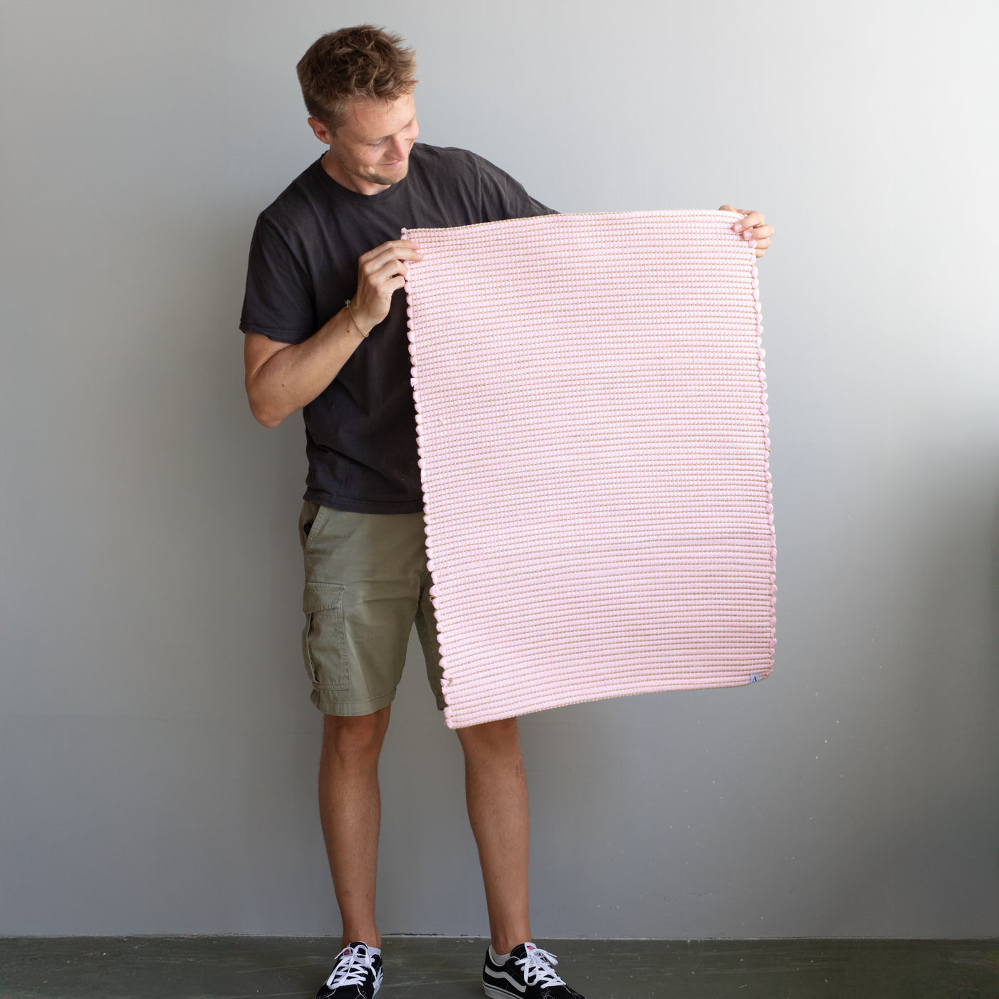 60x90cm petit tapis tenu par une personne en rose rayé avec du jute tissé à la main au Portugal