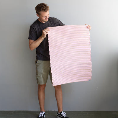 60x90cm petit tapis tenu par une personne en rose rayé avec du jute tissé à la main au Portugal