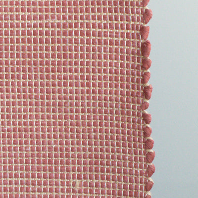 Close-up d'un tapis de bain rouge à rayures de jute fabriqué à partir de chutes de laine provenant de l'industrie textile et tissé à la main au Portugal