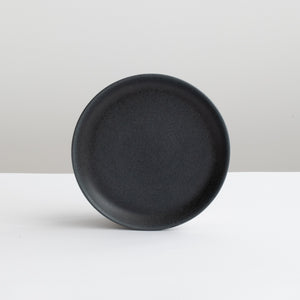 Matt black round saucer with a diameter of 15.5 cm against a light gray background