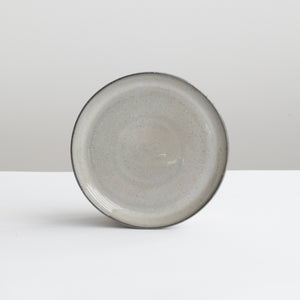 Light gray stone tapas plate with reactive glaze and dark gray rim
