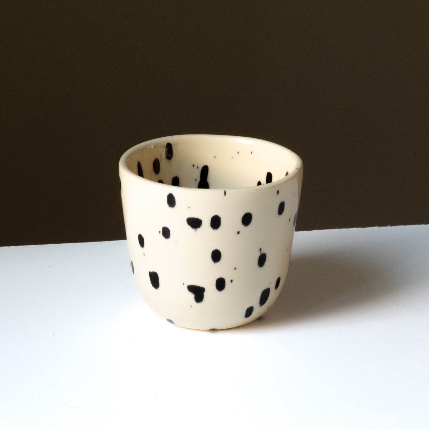 Cappuccino mug in cream color with black splashes of paint