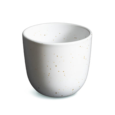 Weisse Kaffeetasse ohne Henkel mit feinen goldenen Punkten freigestellt vor weissem Hintergrund