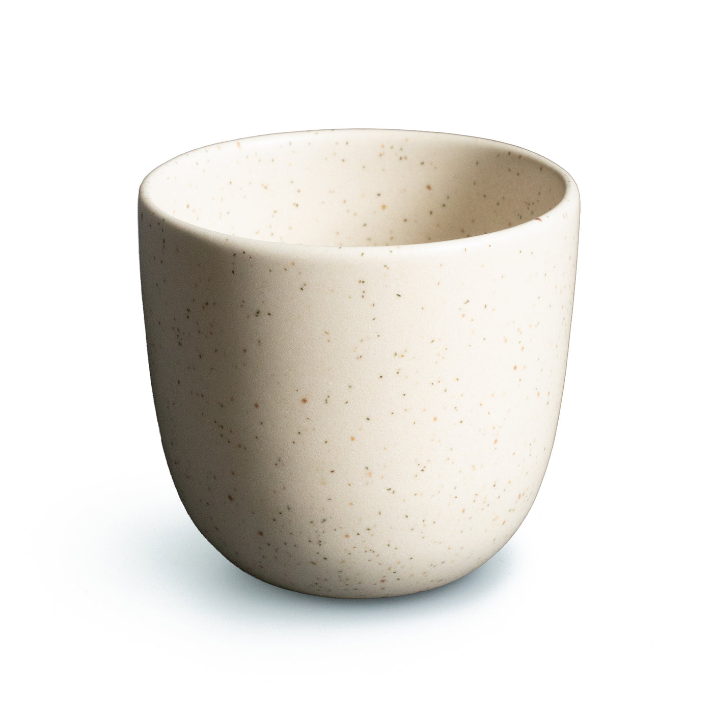 Beige Kaffeetasse mit feinen Sprenklern vor weissem Hintergrund freigestellt