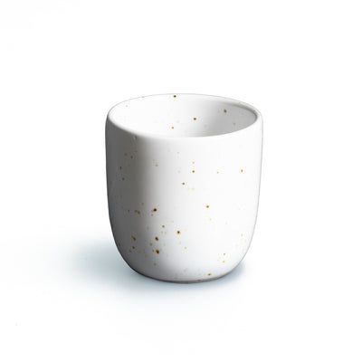 Espresso Tasse ohne Henkel in weiss mit goldenen Sprenklern vor weissem Hintergrund freigestellt