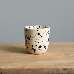 Stoneware espresso mug retains heat with cream-colored glaze with black dots