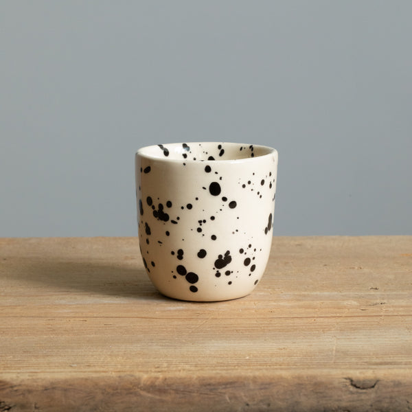Stoneware espresso mug retains heat with cream-colored glaze with black dots