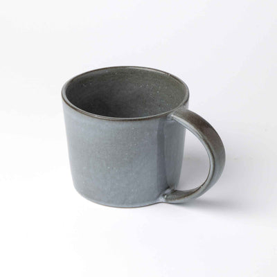 Graublaue Teetasse mit einem Henkel wirkt wie die stürmische See