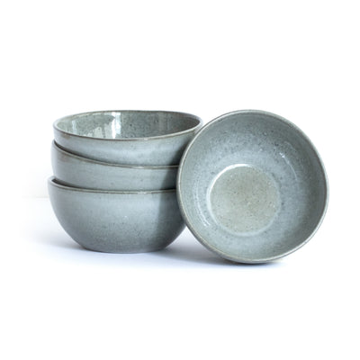 Grande coupe à snacks gris foncé de forme ronde et organique, posée et empilée sur un fond blanc.
