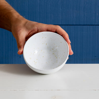 Large white snack bowl held upright with one hand.