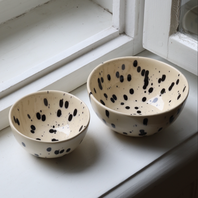 Two snack bowls, one large and one small, next to each other for size comparison in beige with black dots