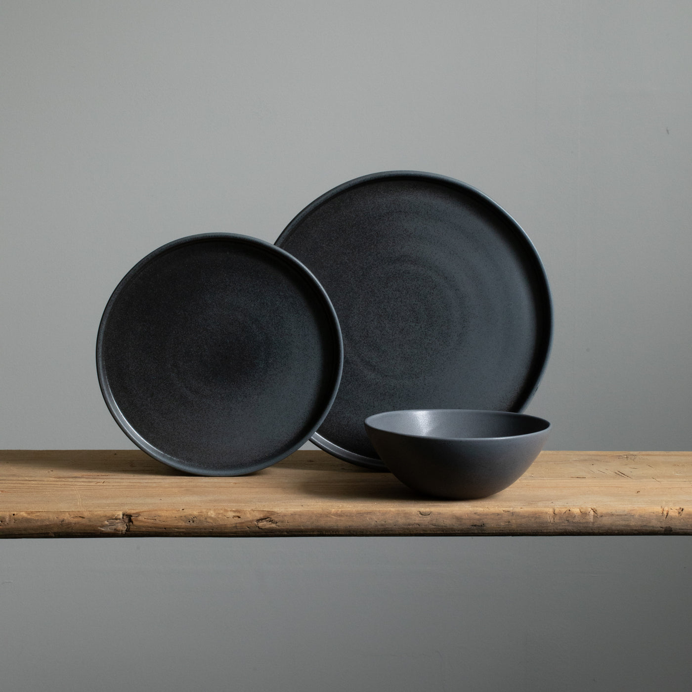 Tableware set with large and small plates and a cereal bowl in matt black