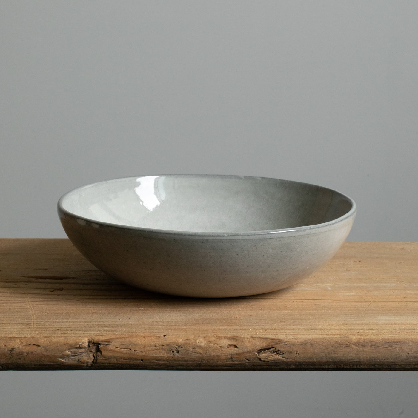 Assiette creuse gris clair vue de face avec un bord de 6cm de haut