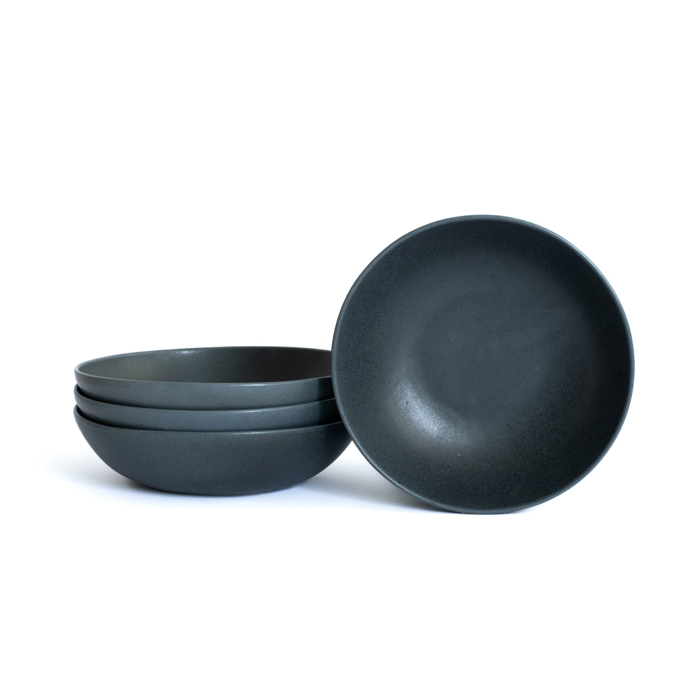 Assiette de pâtes noire mate détachée sur fond blanc