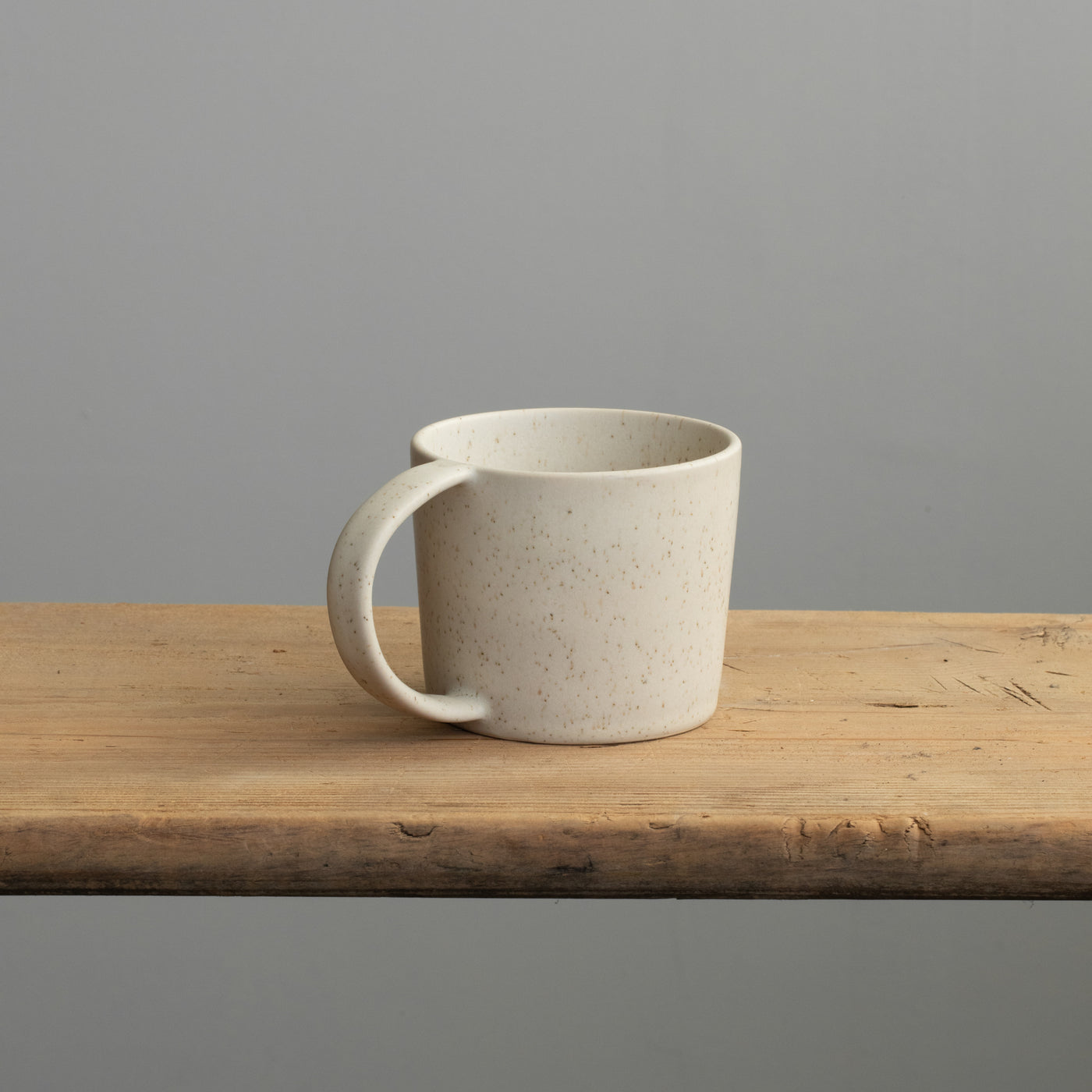 Tee Tasse mit Henkel in beige auf einem Holztisch