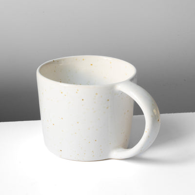 Large white tea cup with fine golden speckles and large round handle