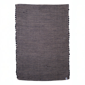 Small jute striped rug in black made from wool remnants hand-woven in Portugal in front of a white background